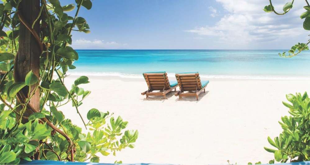 Two beach loungers on a beach in Antigua.