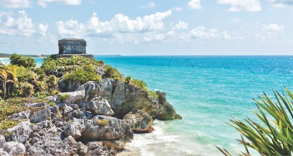 A small beach in Mexico surrounded by rocks.